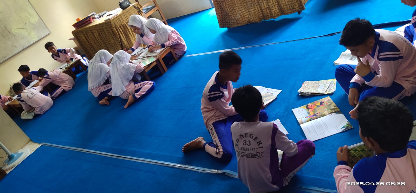 Anak kelas VI Sedang berkunjung ke perpustakaan dan membuat jurnal baca.